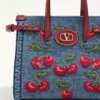 Valentino Garavani Antibes Kleine Einkaufstasche aus Denim mit Cherryfic-Stickerei Valentino Garavani Antibes Kleine Einkaufstasche aus Denim mit Cherryfic-Stickerei