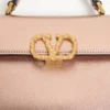 Valentino Garavani Vsling Mini-Handtasche aus laminiertem genarbtem Kalbsleder mit Juwelenlogo Valentino Garavani Vsling Mini-Handtasche aus laminiertem genarbtem Kalbsleder mit Juwelenlogo