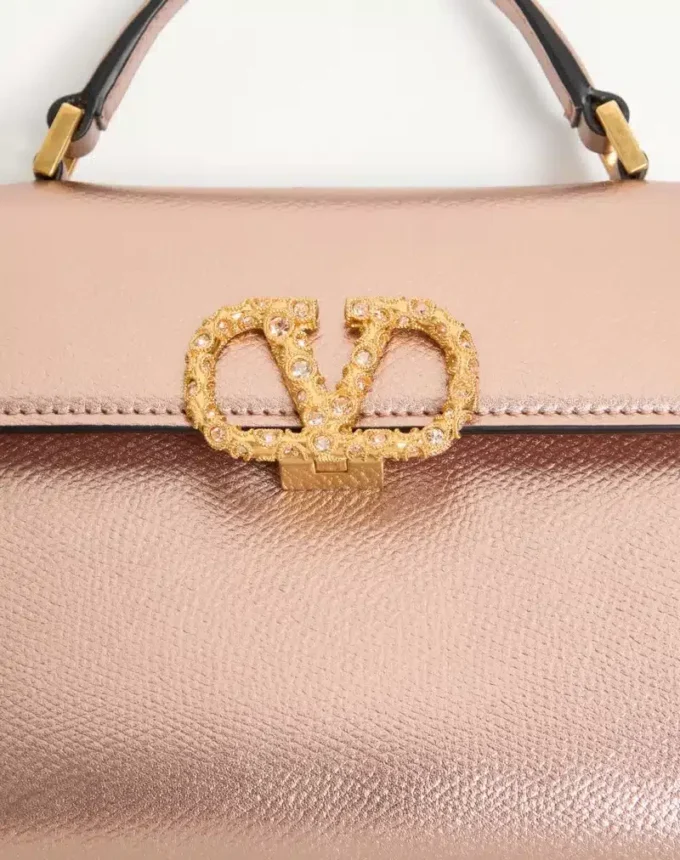 Valentino Garavani Vsling Mini-Handtasche aus laminiertem genarbtem Kalbsleder mit Juwelenlogo Valentino Garavani Vsling Mini-Handtasche aus laminiertem genarbtem Kalbsleder mit Juwelenlogo
