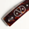 Vlogo Signature Haarspange aus Harz, Metall und Kristallen Vlogo Signature Haarspange aus Harz, Metall und Kristallen
