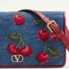 Vlogo Signature Mini-Denim-Umhängetasche mit Cherryfic-Stickerei Vlogo Signature Mini-Denim-Umhängetasche mit Cherryfic-Stickerei